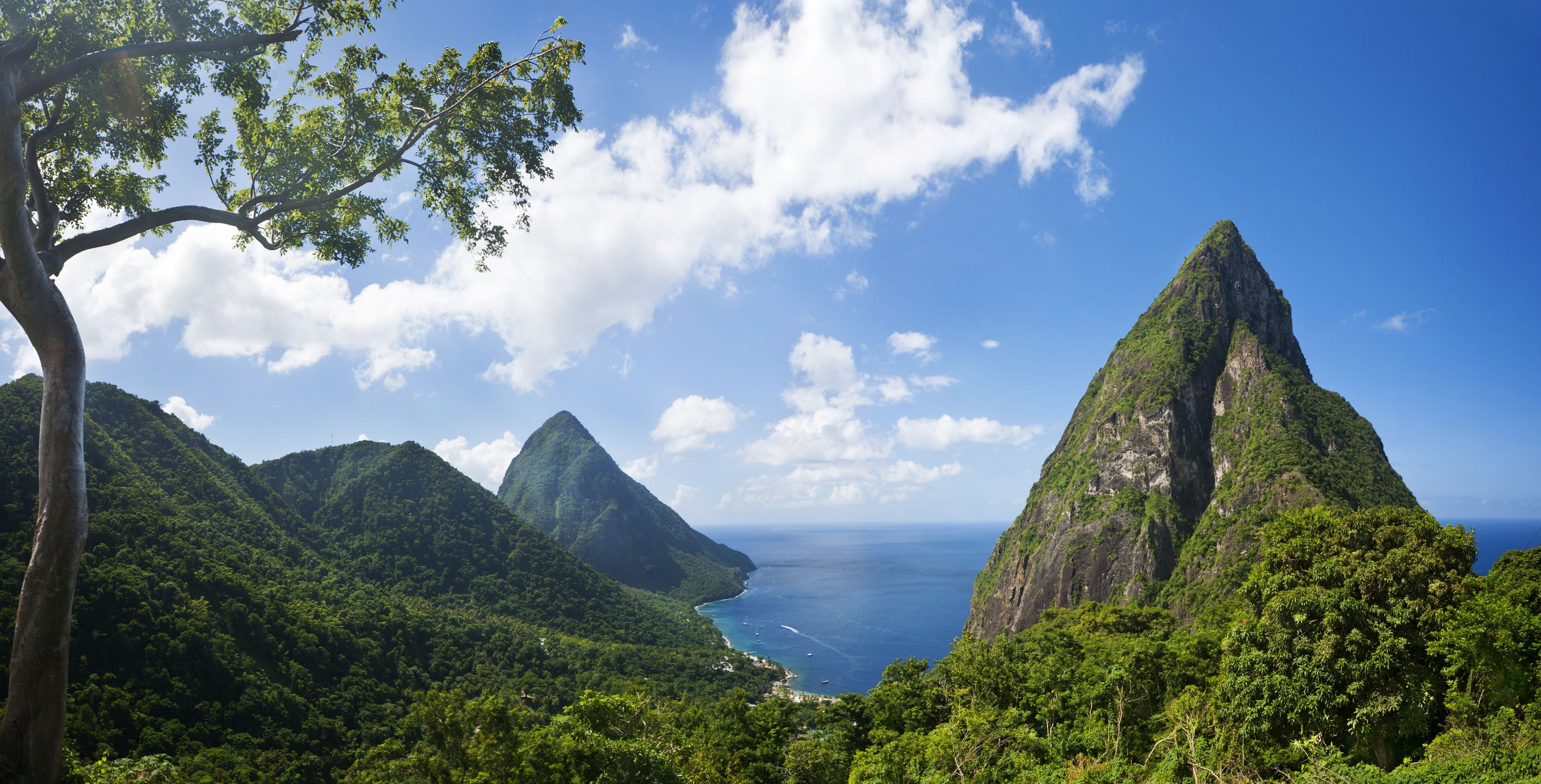 A mountainous landscape with lush greenery and a clear view of the ocean.