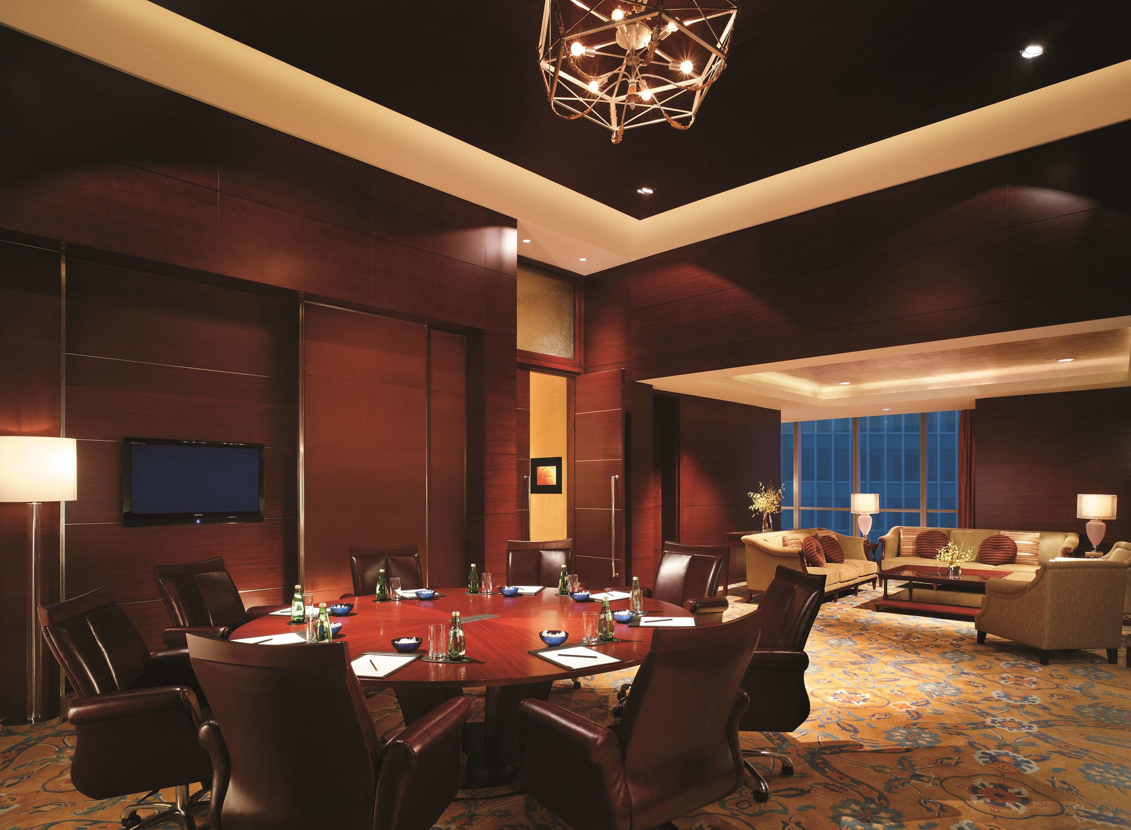 A conference room with a large table, chairs, and a television on the wall.