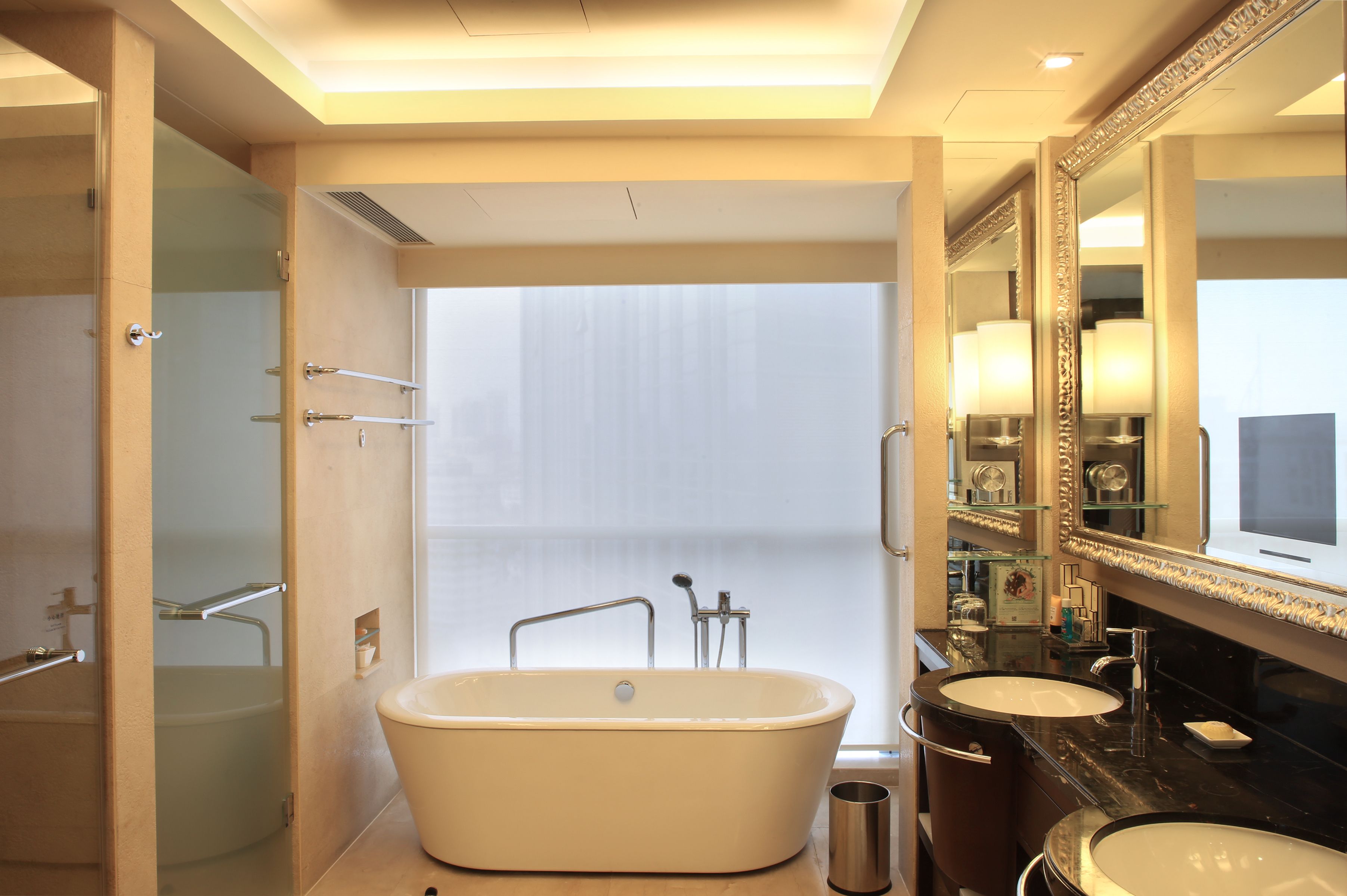 A bathroom with a freestanding bathtub, a double sink, and a large mirror.