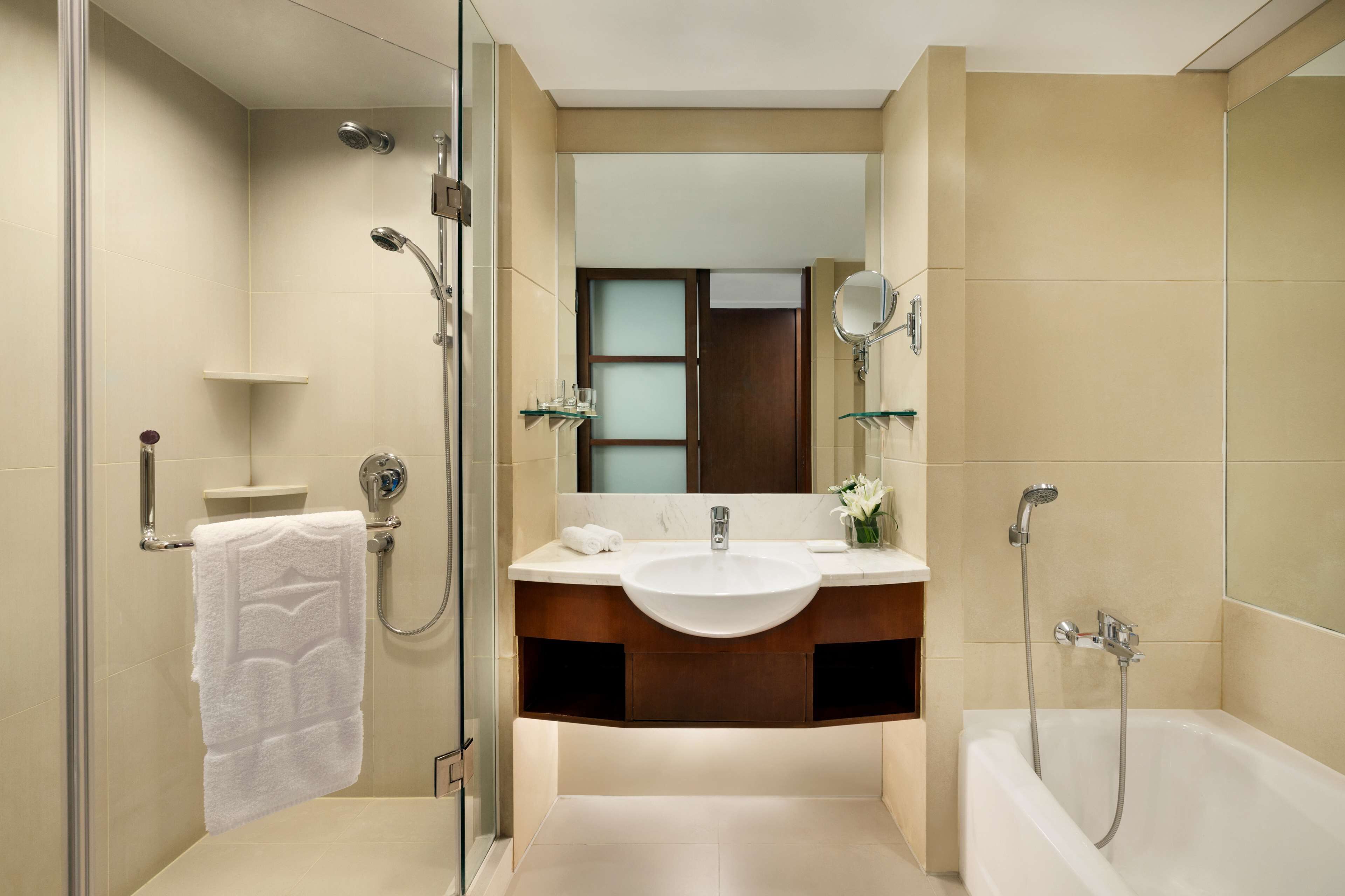 A modern bathroom with a glass-enclosed shower, a vanity with a sink, and a bathtub.