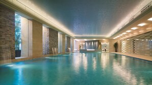 An indoor swimming pool with clear water, stone walls, and a modern ceiling design. - Shangri-La Qingdao (Qingdao)