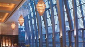 A spacious lobby with high ceilings, large windows, and modern chandeliers. - Shangri-La Qingdao (Qingdao)