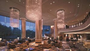 A spacious lobby with high ceilings, large chandeliers, and a variety of seating arrangements. - Shangri-La Qingdao (Qingdao)