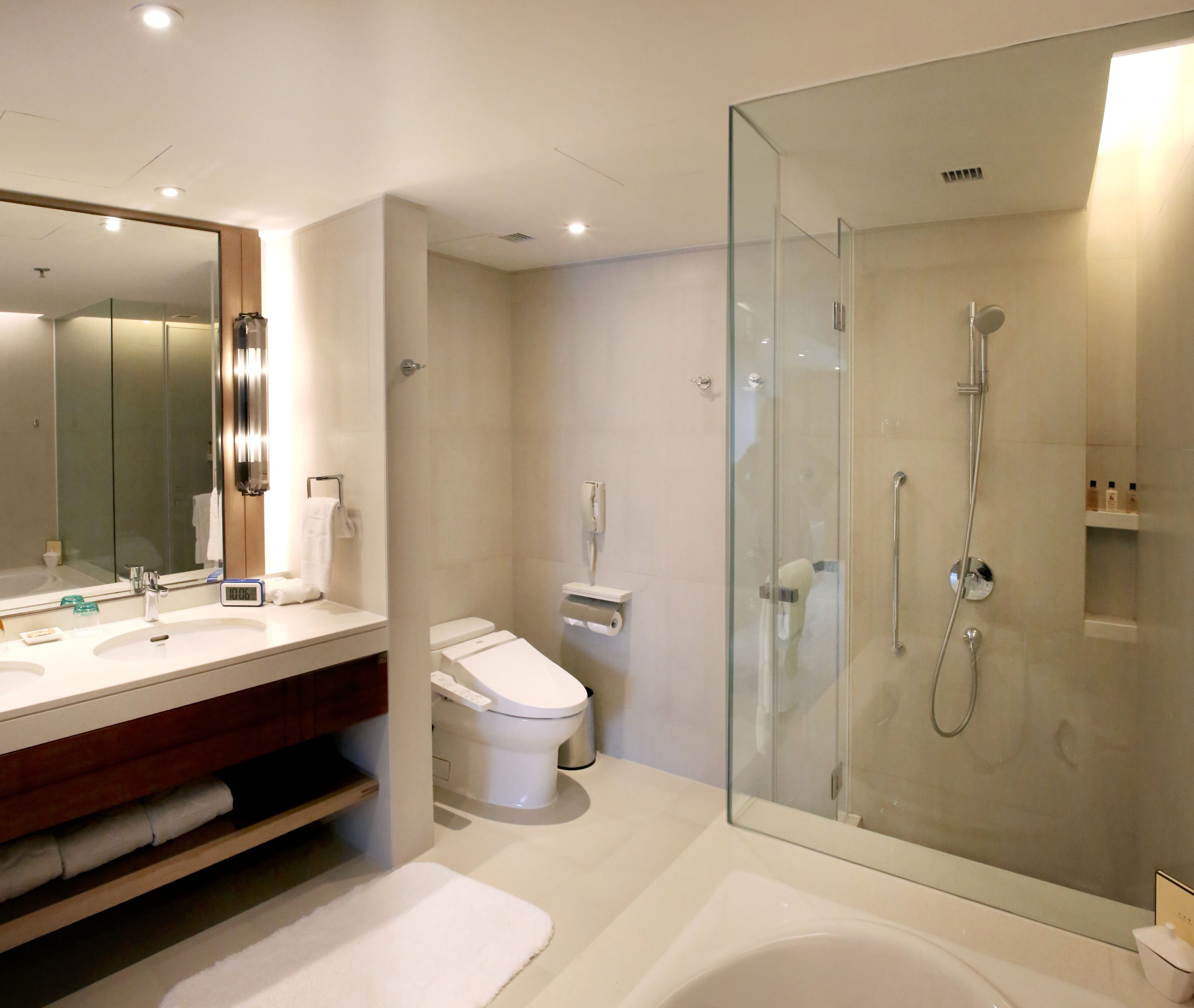 A modern bathroom with a glass-enclosed shower, a white sink, and a toilet.