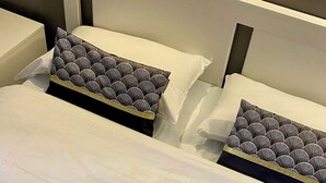 A hotel room with two beds, each with matching pillows and a tray with breakfast items including a croissant, coffee, and cereal. - Aix Hotel (Aix-en-Provence)