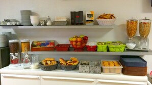 A buffet setup with various food items and containers. - Aix Hotel (Aix-en-Provence)