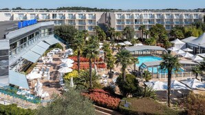 Un hôtel doté de nombreux balcons, d’une piscine et d’espaces de détente en plein air.