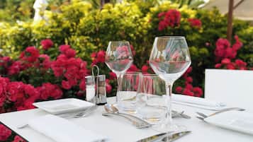 Une table mise pour le dîner, avec des verres à vin, des couverts et un salier et un poivrier.
