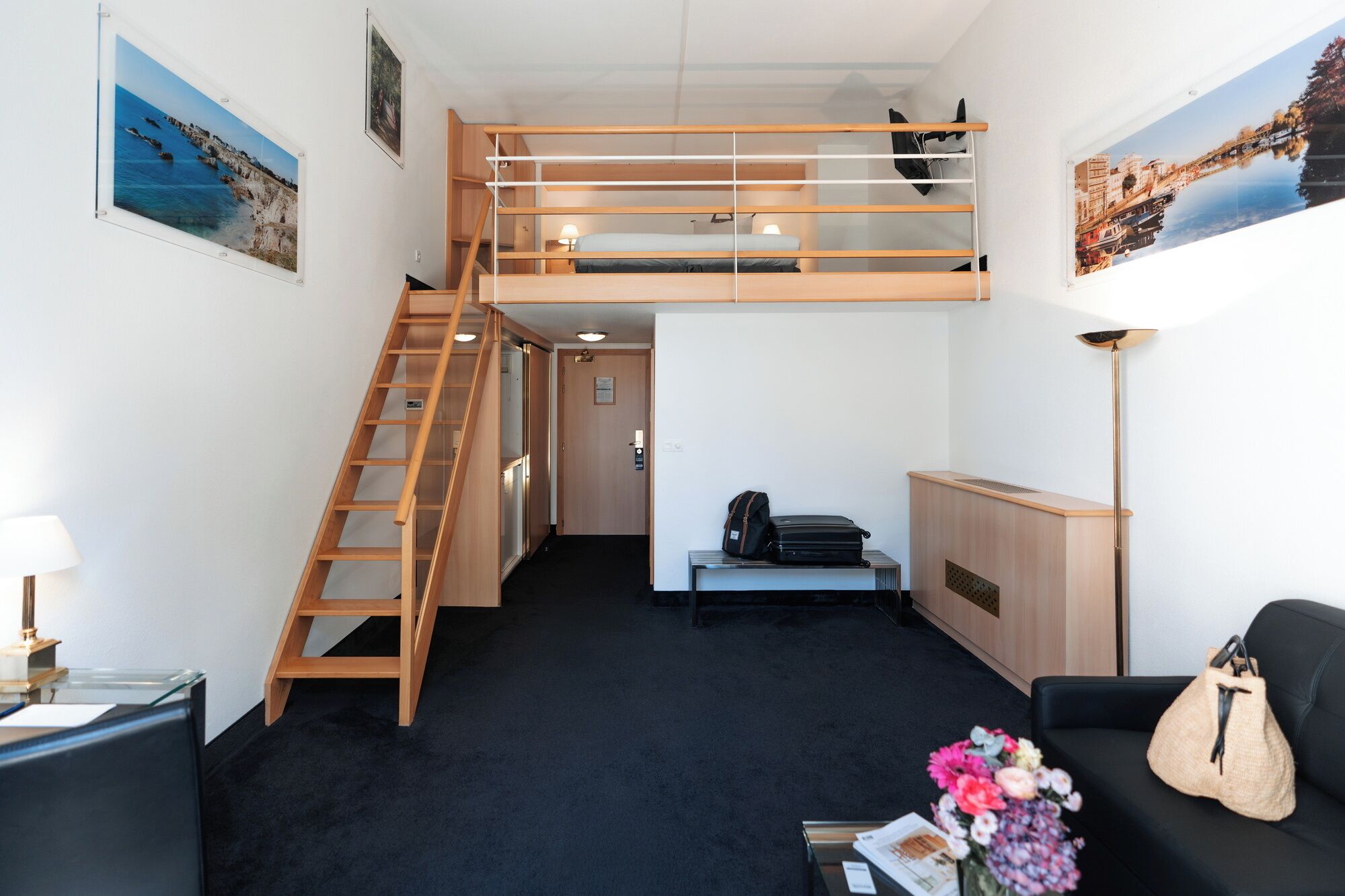 Une petite pièce comprenant un lit superposé, un bureau, une chaise, une lampe et un canapé.