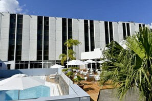 Una piscina al aire libre, sombrillas