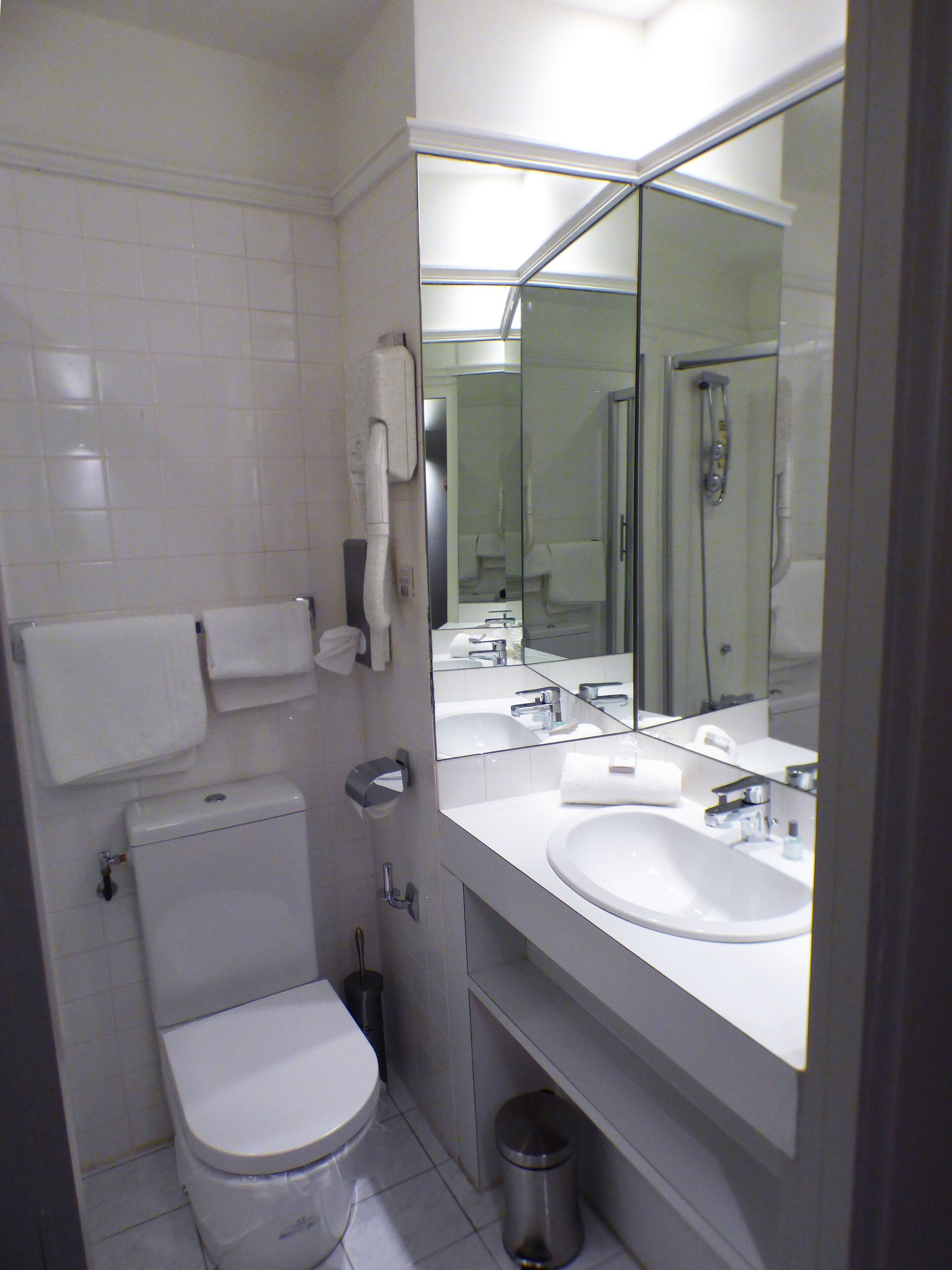 A modern bathroom with a toilet, sink, and shower.
