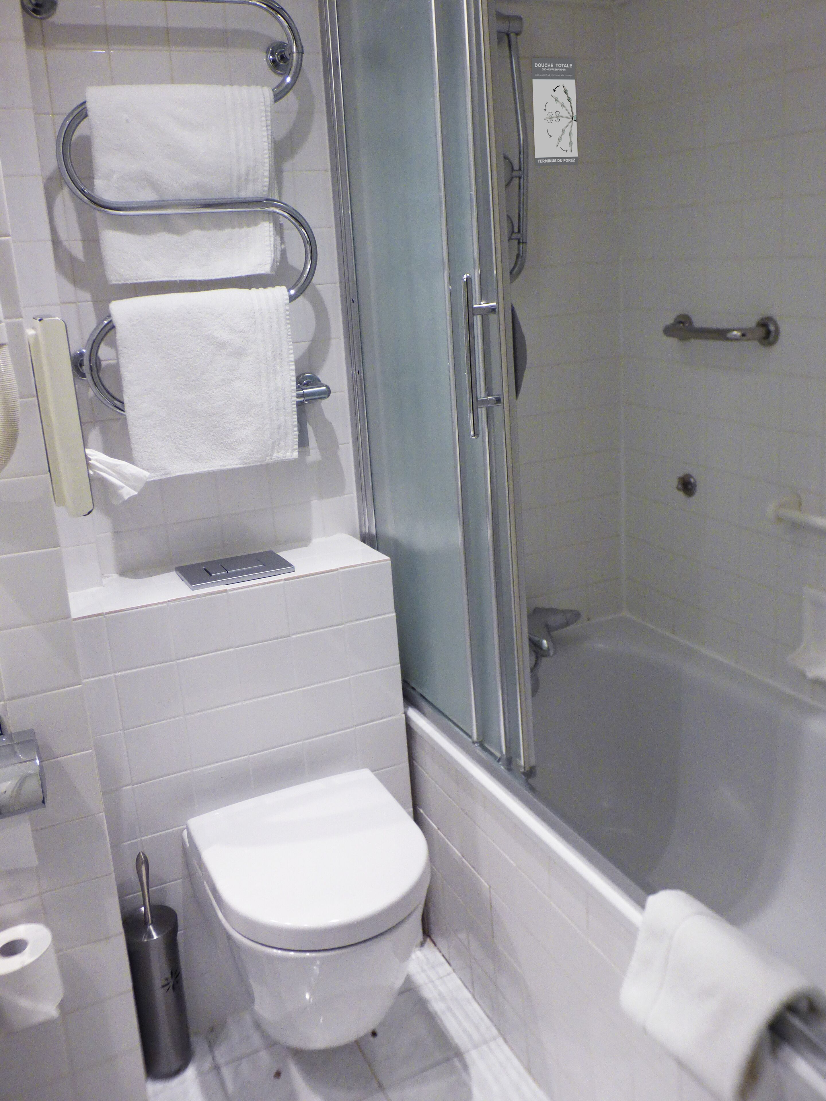 A bathroom with a toilet, a shower, and a sink.