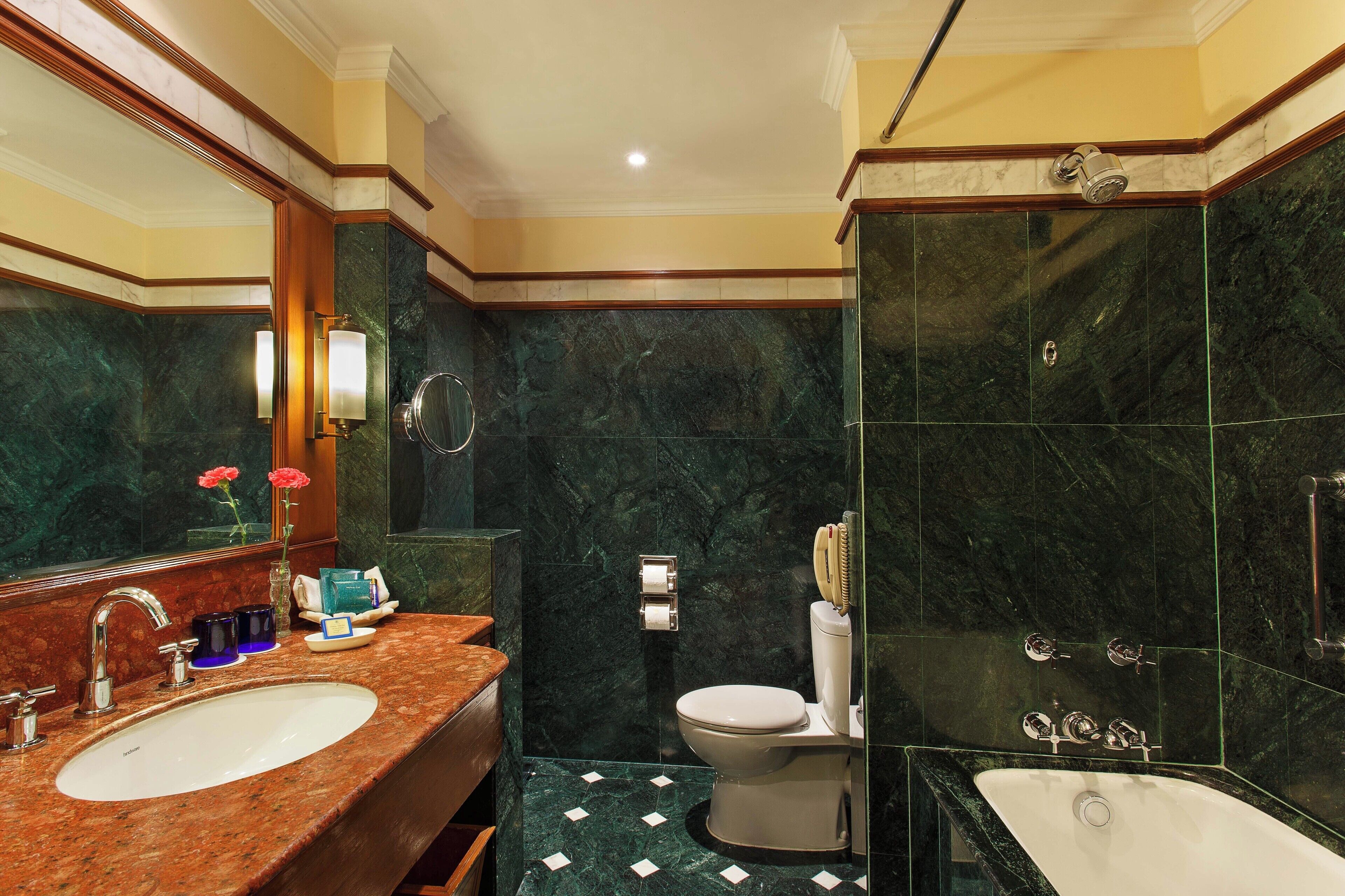 Une salle de bain avec un lavabo en marbre, des toilettes et une baignoire.