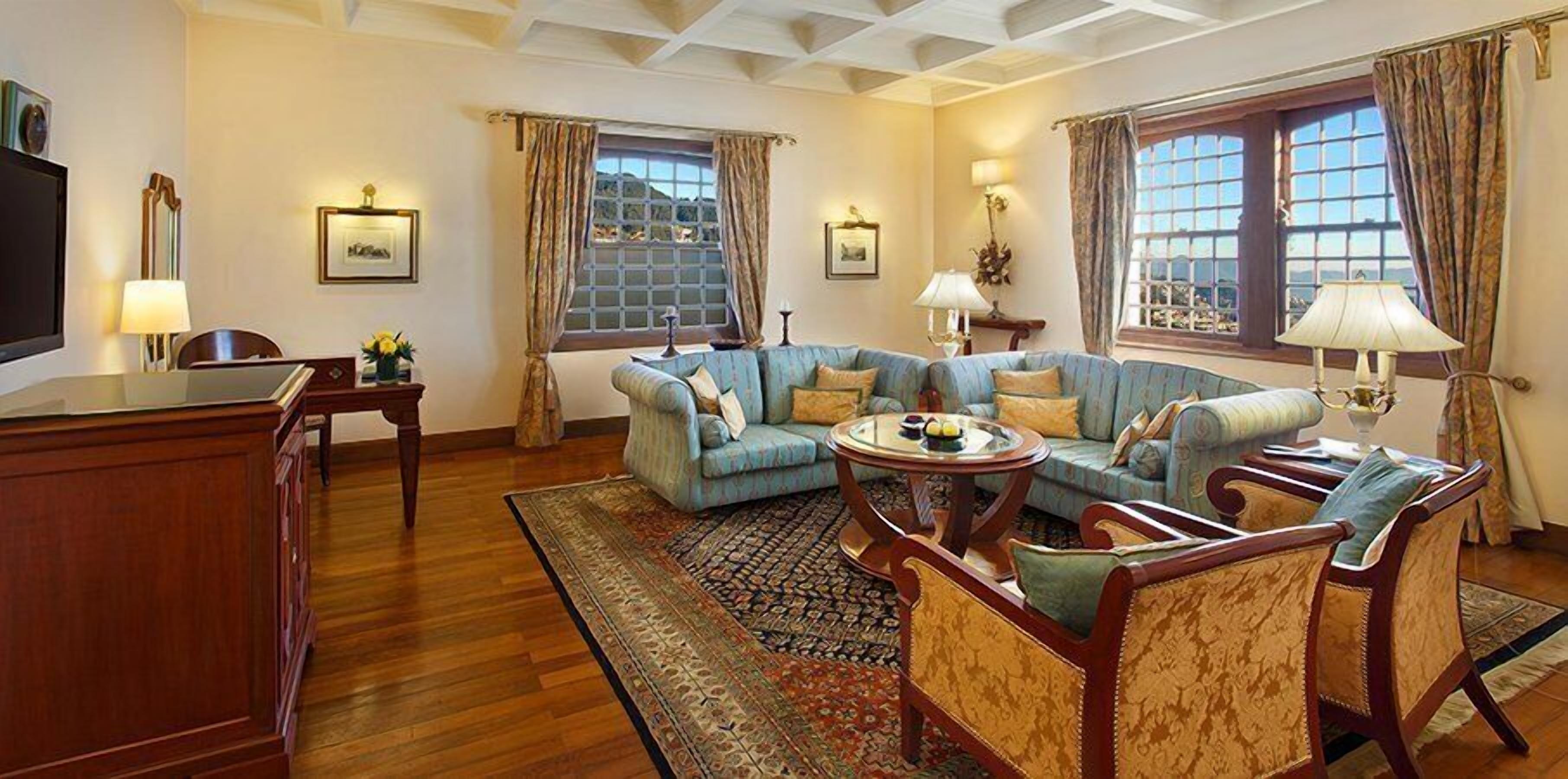 A living room with a sofa set, a coffee table, and a wooden desk.