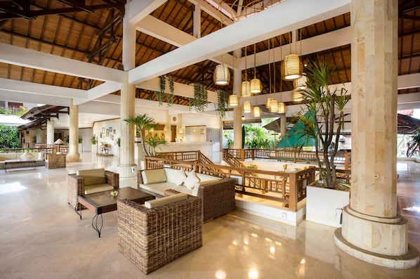 A spacious lobby with wicker furniture, a wooden staircase, and hanging wicker lamps. - SOL by Melia Benoa Bali - All Inclusive (Nusa Dua)