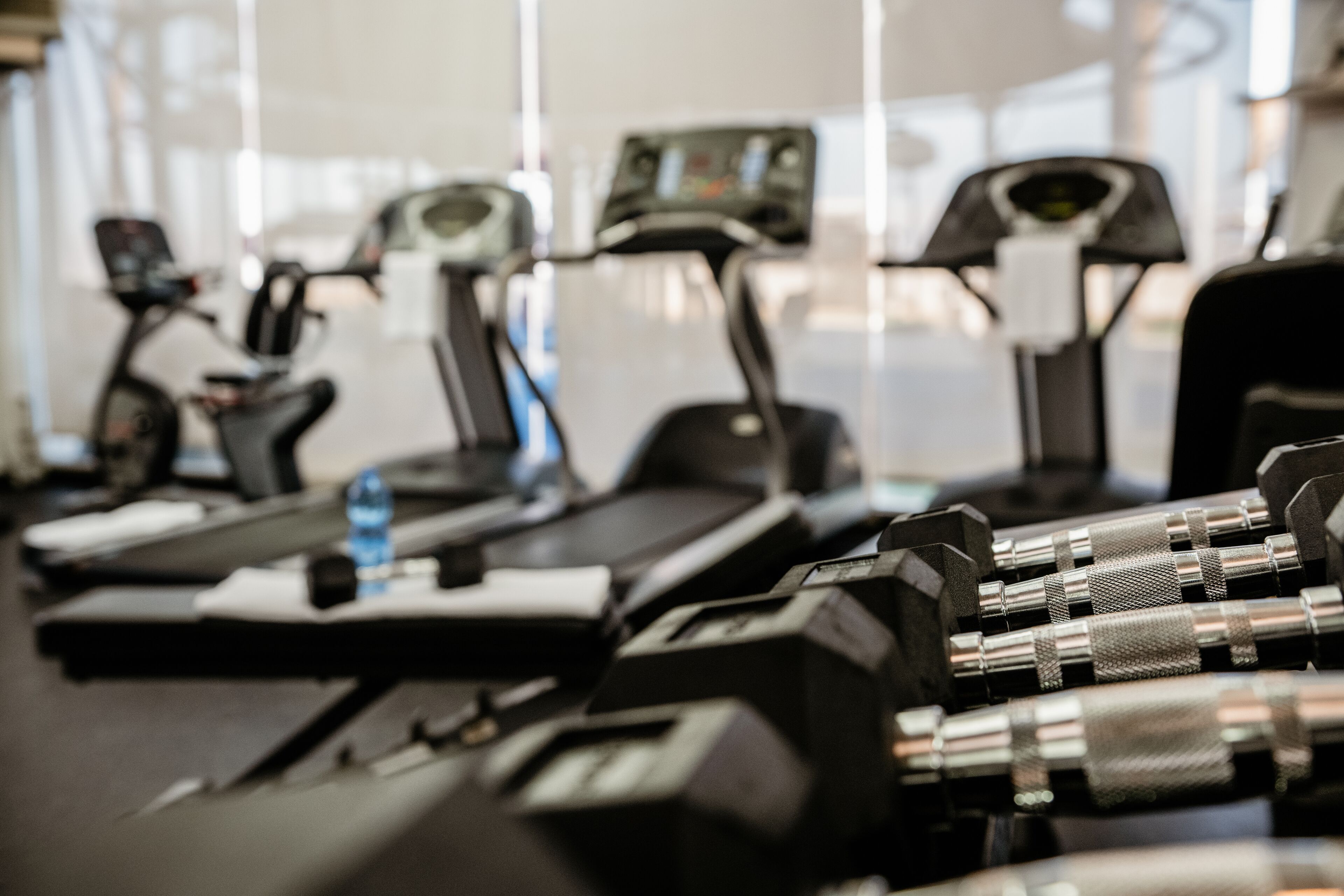 Un gimnasio con cintas de correr y equipo de ejercicio.