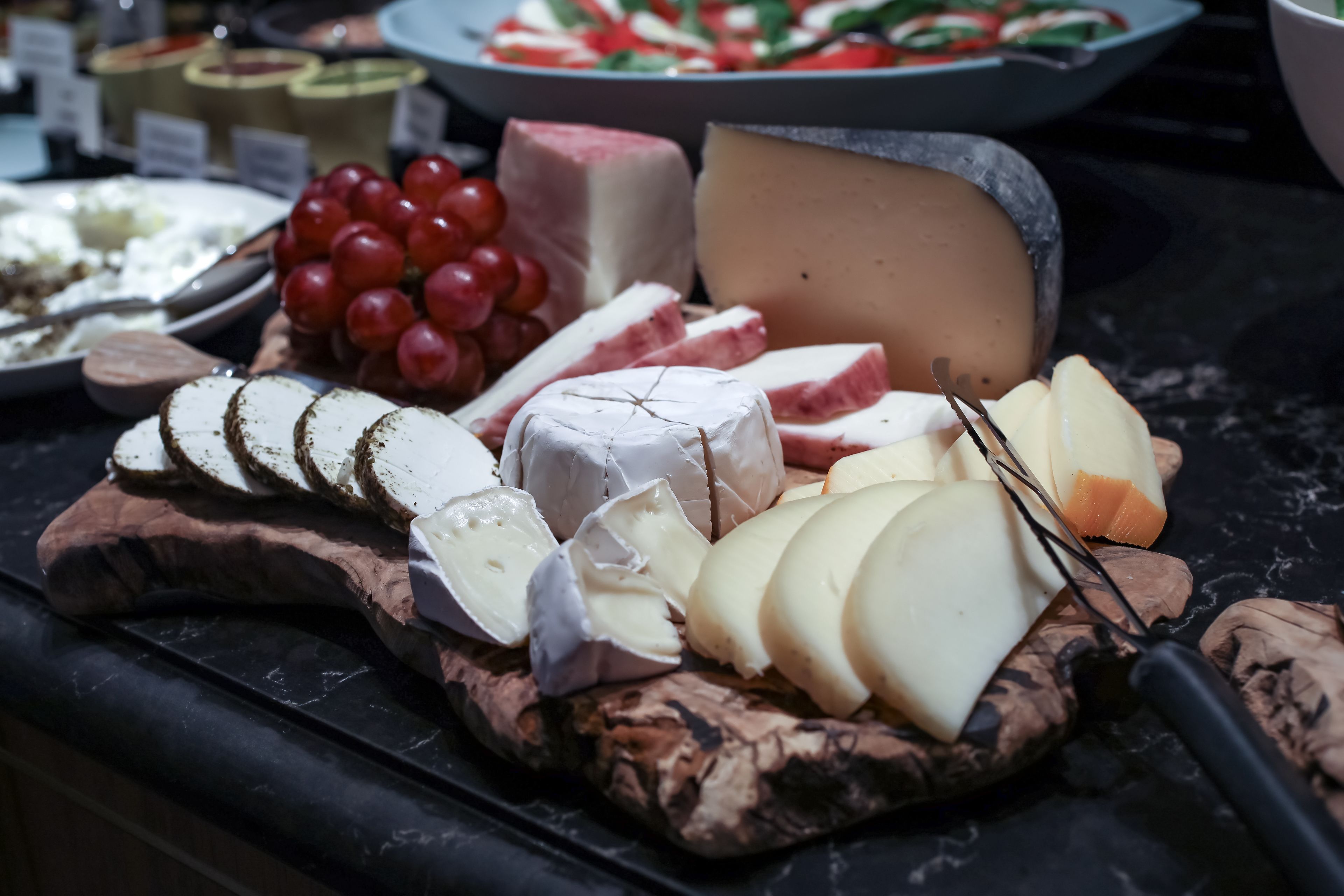 Una tabla de quesos y embutidos con uvas.