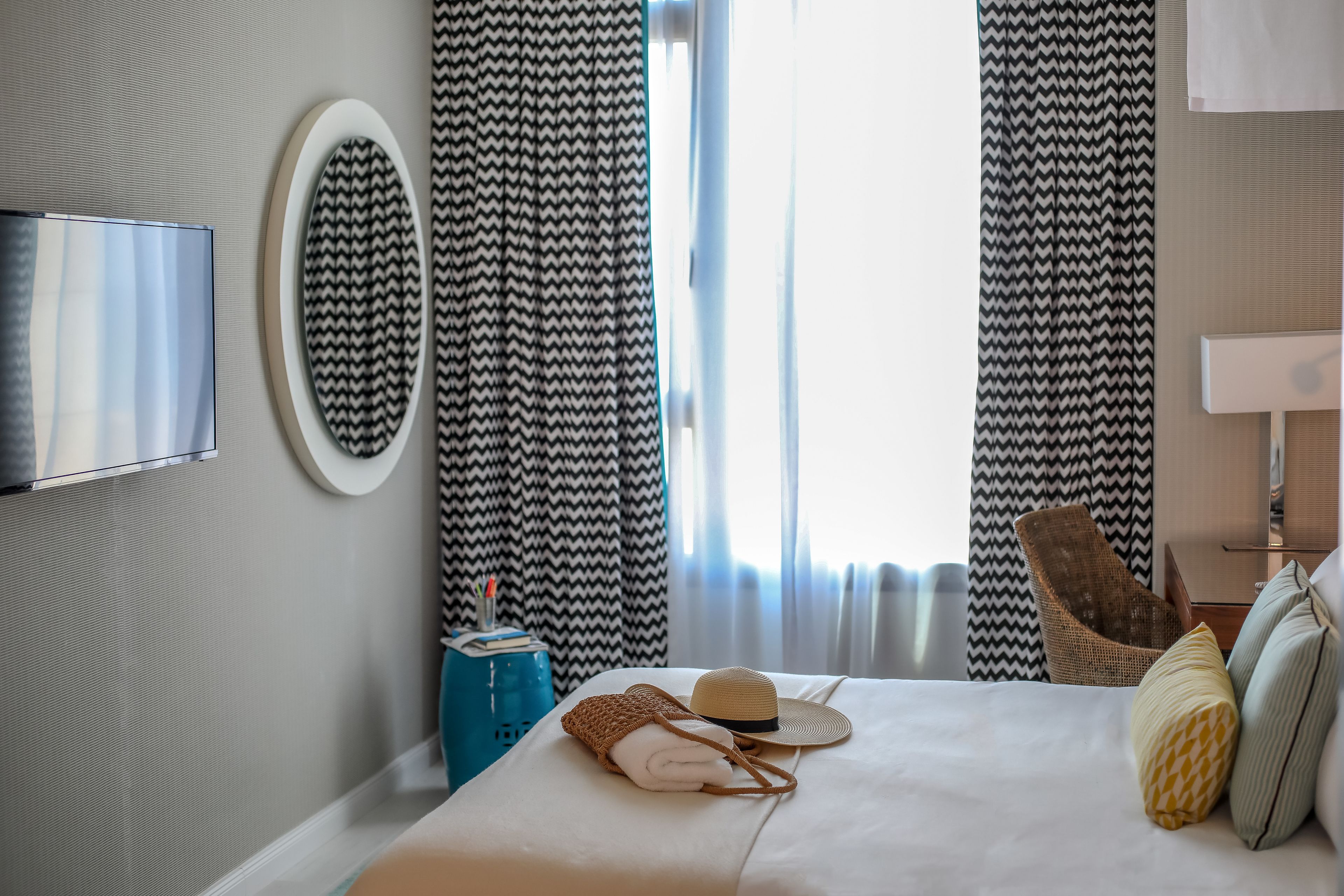 Een hotelkamer met een bed, een televisie, een stoel en gordijnen.