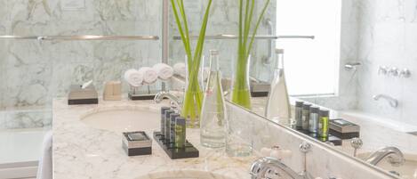 A bathroom with two sinks, a large mirror, and toiletries on the counter.