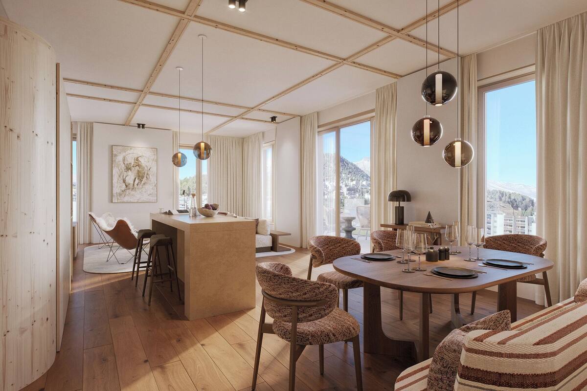 Un vaste espace dédié à la salle à manger, avec un îlot central, une table ronde et des chaises à motifs.