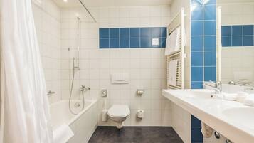 A bathroom with a bathtub, toilet, and sink.