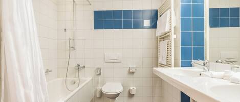 A bathroom with a bathtub, toilet, and sink.