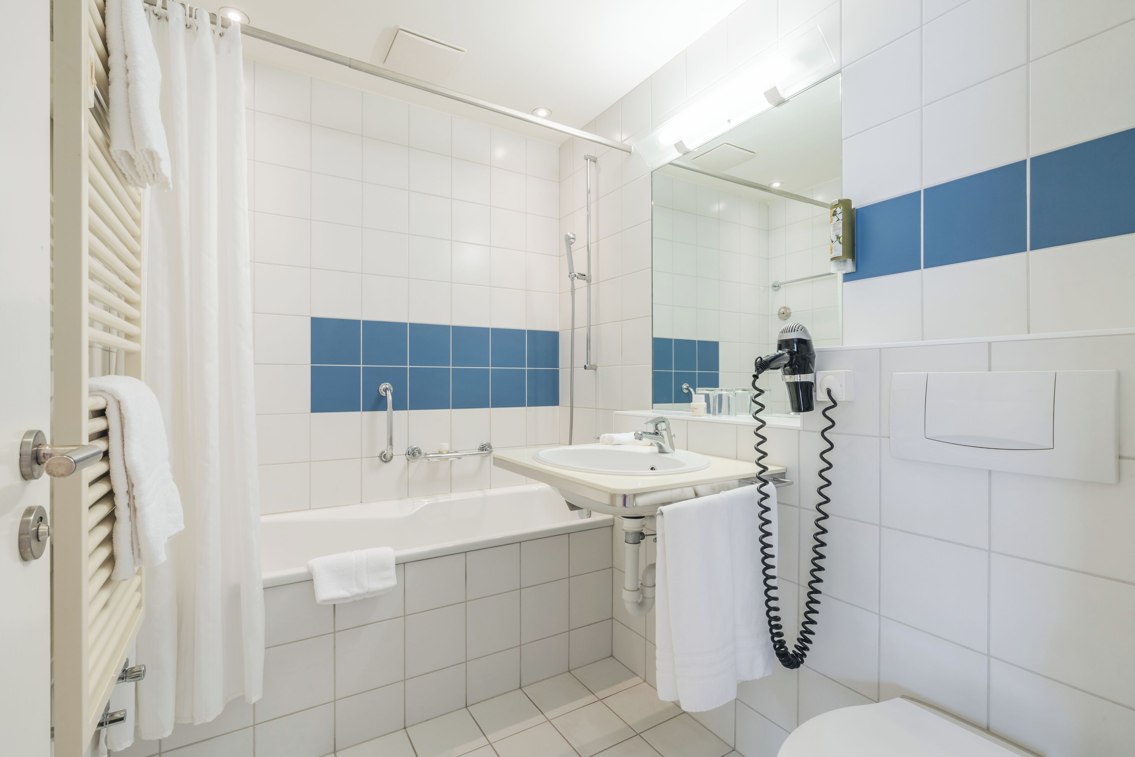 Un baño moderno con bañera, lavamanos e inodoro.