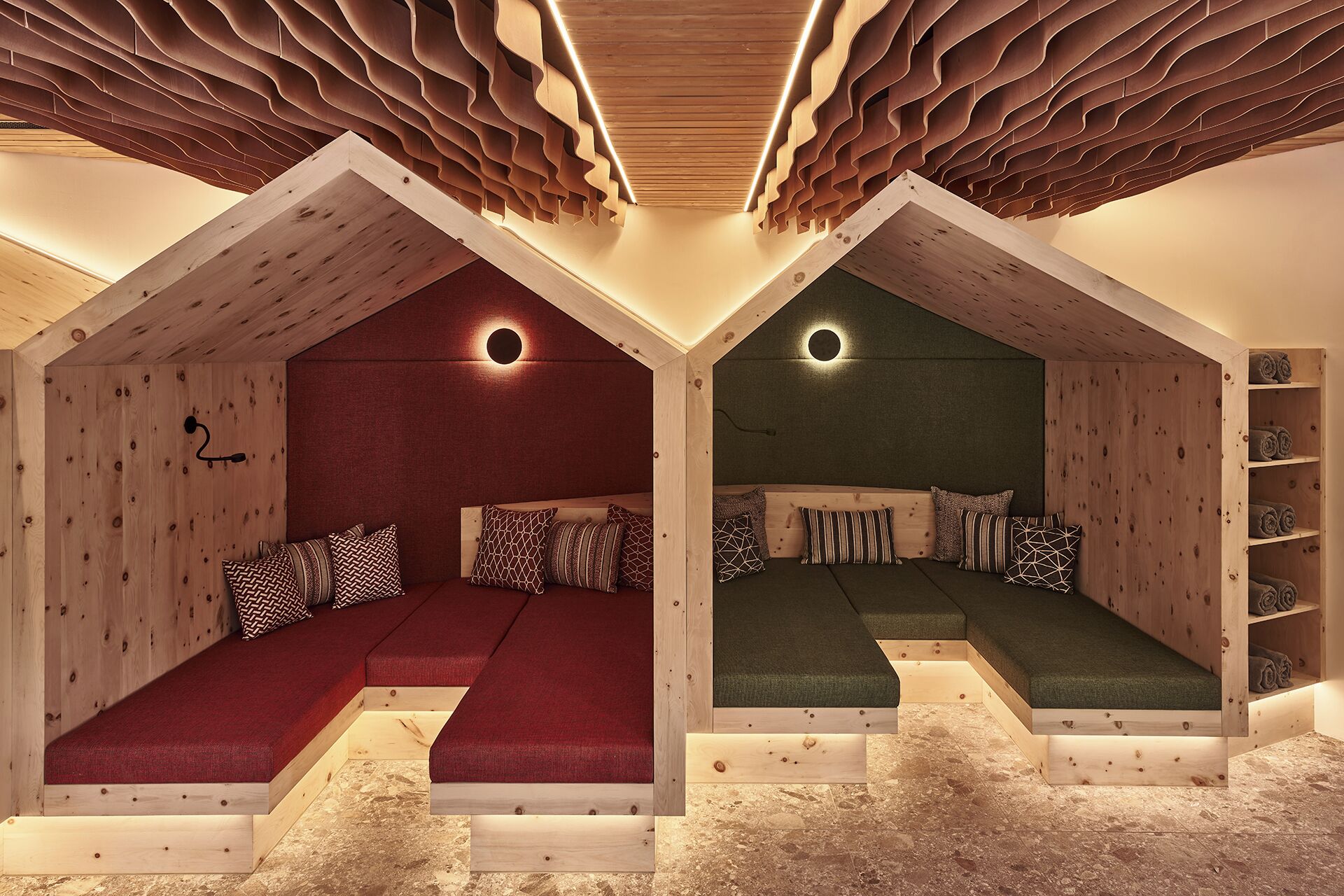 A cozy attic bedroom with two distinct sleeping areas, each with a unique color scheme and a circular light fixture above the bed.