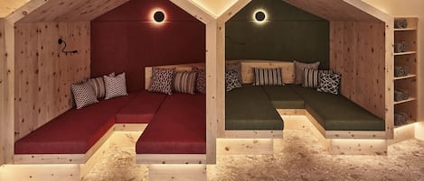 A cozy attic bedroom with two distinct sleeping areas, each with a unique color scheme and a circular light fixture above the bed.
