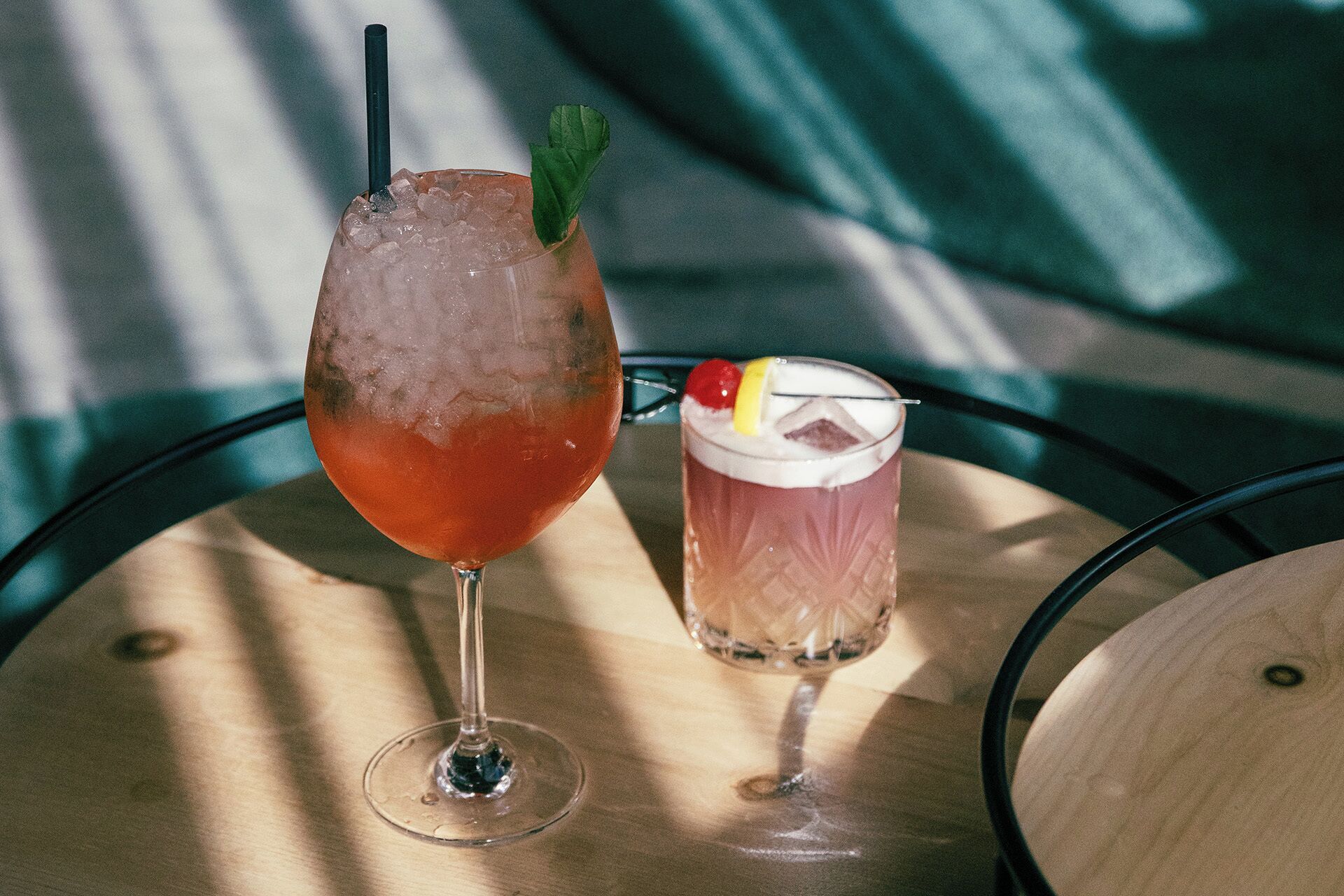 Dos bebidas sobre una mesa redonda con superficie de madera.