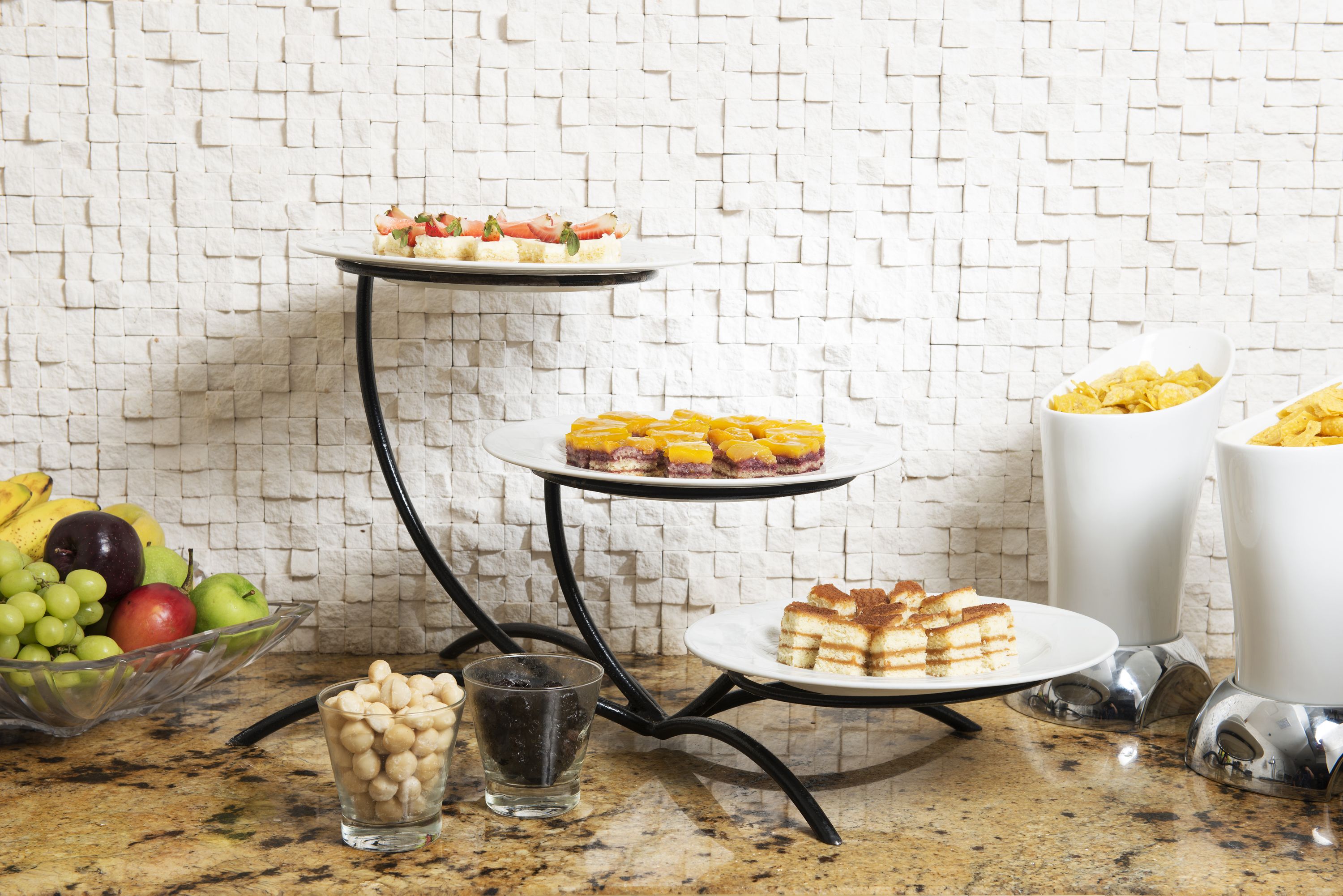Une table de buffet avec divers plats et un saladier de fruits.