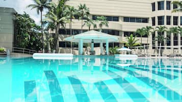 Una piscina al aire libre, sombrillas