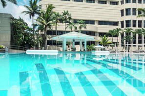 Una piscina al aire libre, sombrillas