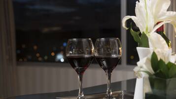 Two wine glasses on a tray with a white flower vase.