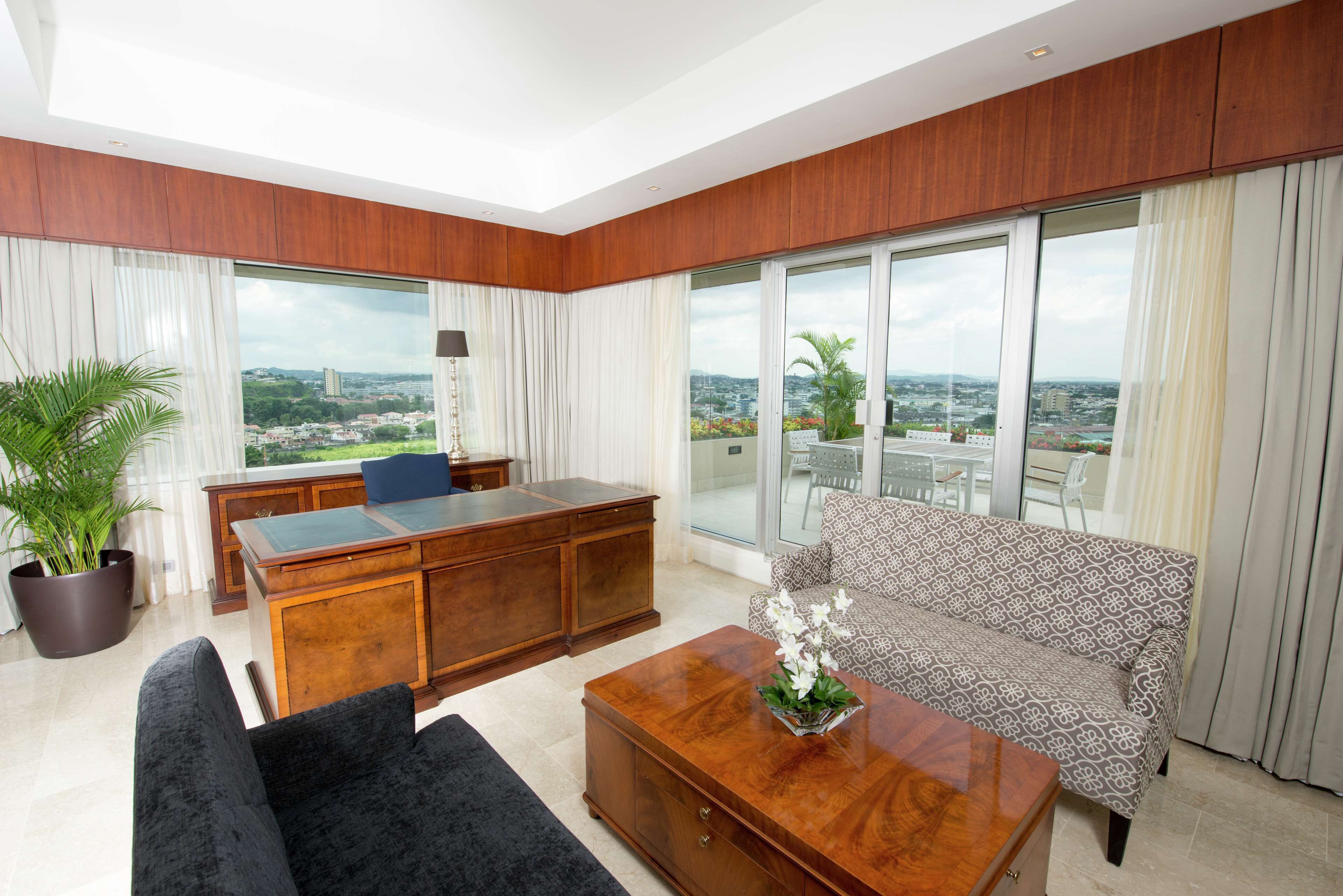 A modern living room with a large desk, sofa, and coffee table.