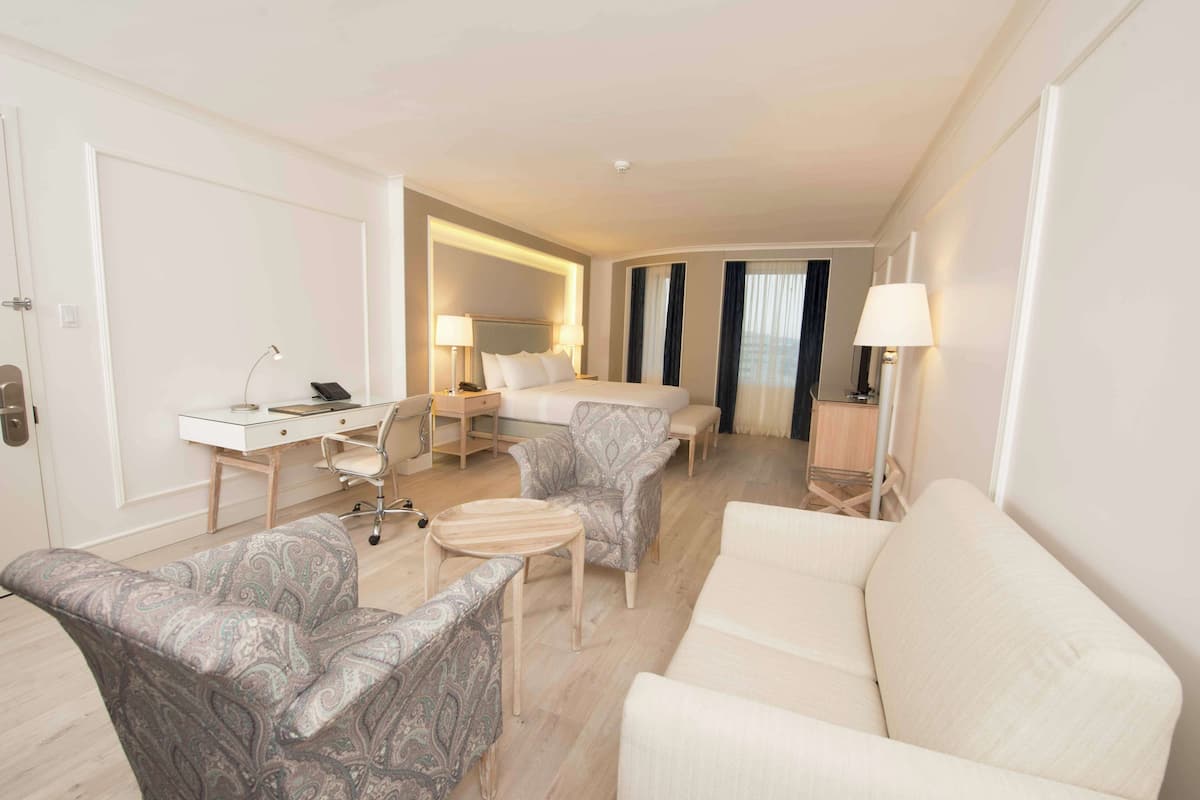 Junior Suite, 1 King Bed | Living area | 42-inch Smart TV with cable channels, TV, iPod dock