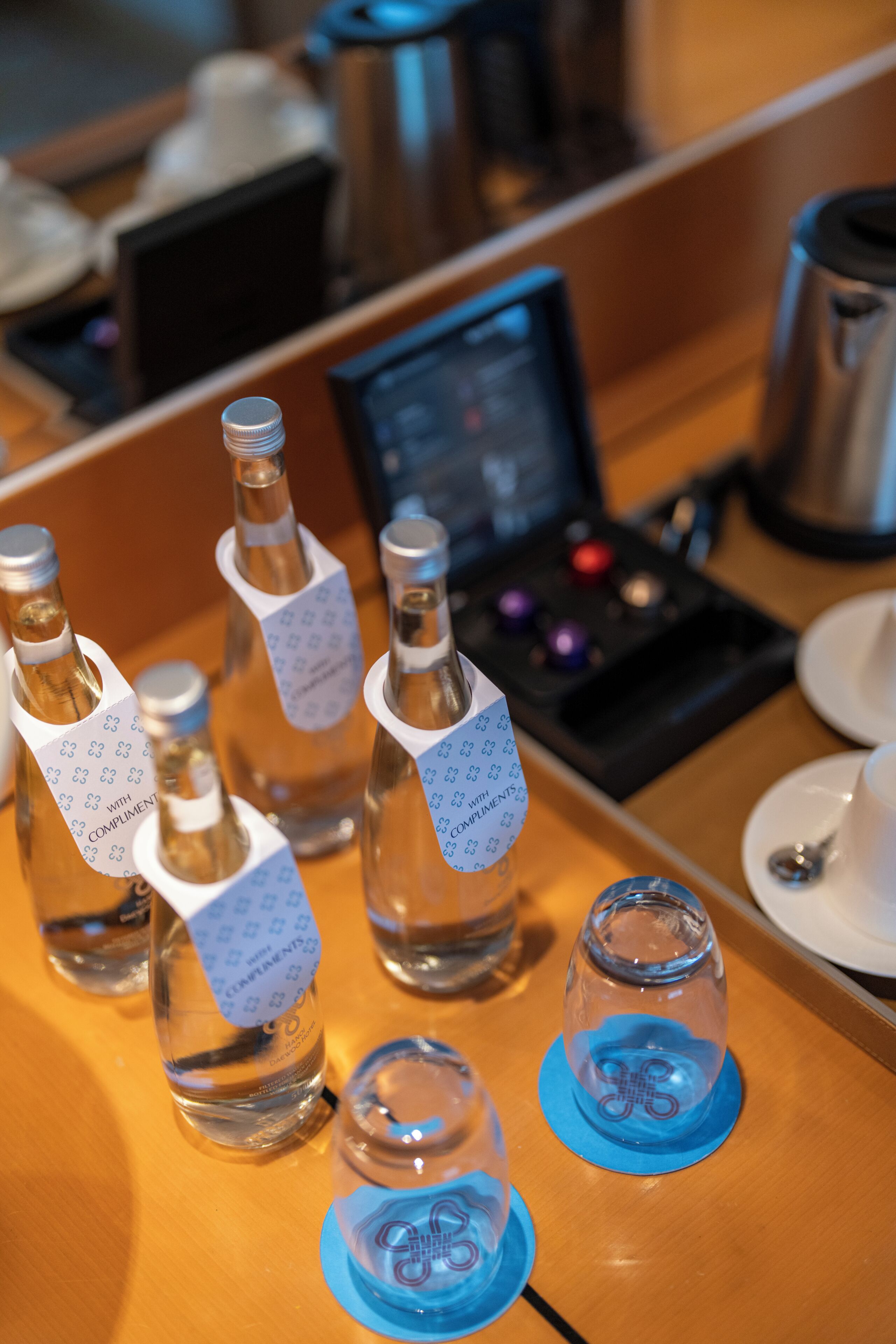 Bottles of water with labels on a wooden table.
