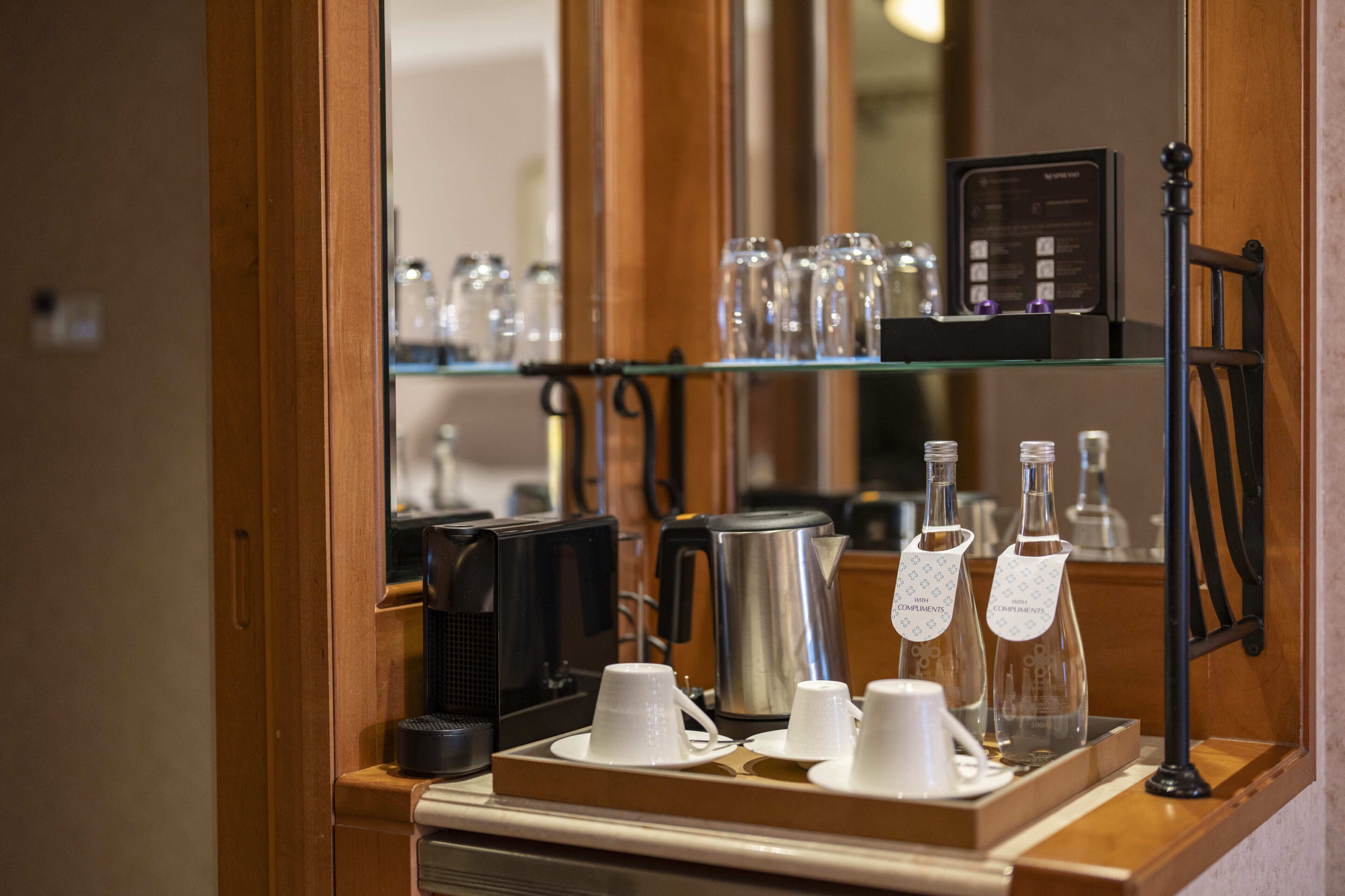 Una estación de café con cafetera, tazas y tetera.