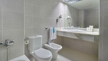 Un baño moderno con inodoro, bidé y bañera.