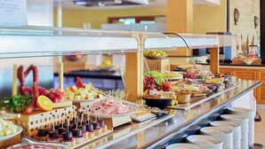 A buffet with various food items and plates. - Sol Tenerife (Arona)