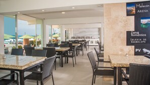 A restaurant with outdoor seating and a view of the sea.