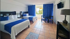 A hotel room with two beds, a TV, a desk, and a view of the outside.