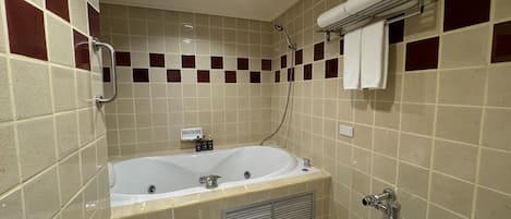 A bathroom with a bathtub, toilet, and shower.