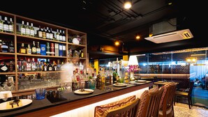 A bar area with shelves of liquor bottles, a bar counter, and seating. - Le Siam Hotel Silom Bangkok by PCL (Bangkok)