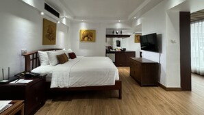 A modern hotel room with a large bed, wooden furniture, a flat-screen TV, and artwork on the walls. - Le Siam Hotel Silom Bangkok by PCL (Bangkok)