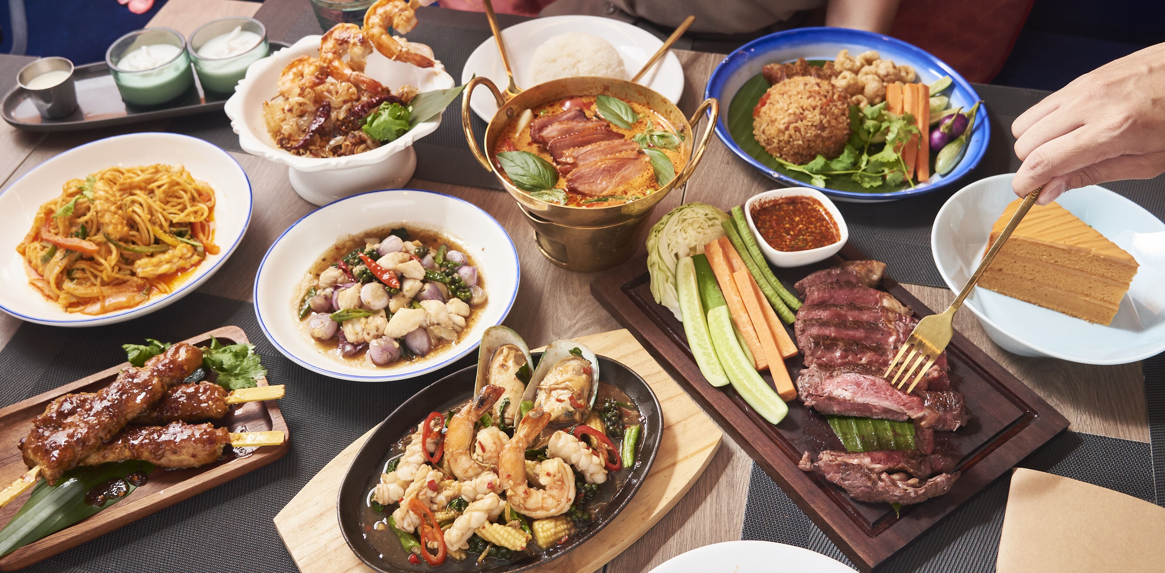 A variety of dishes on a table, including seafood, rice, and vegetables.