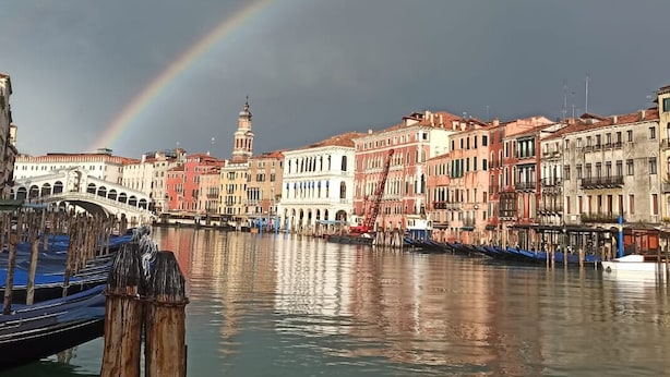 A canal with buildings and a bridge in the background. - Hotel Villa Stella.check-in.9AM-3PM (Venice)