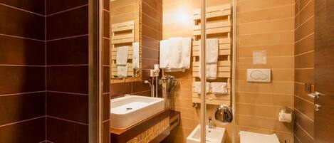 A modern bathroom with a large mirror, a sink, a toilet, and a shower area.