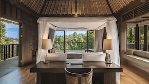 A room with a wooden ceiling, a bed with white linens, two bedside tables with lamps, and a view of the outdoors.