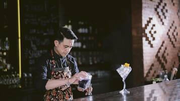 A bartender at a bar, preparing a drink.